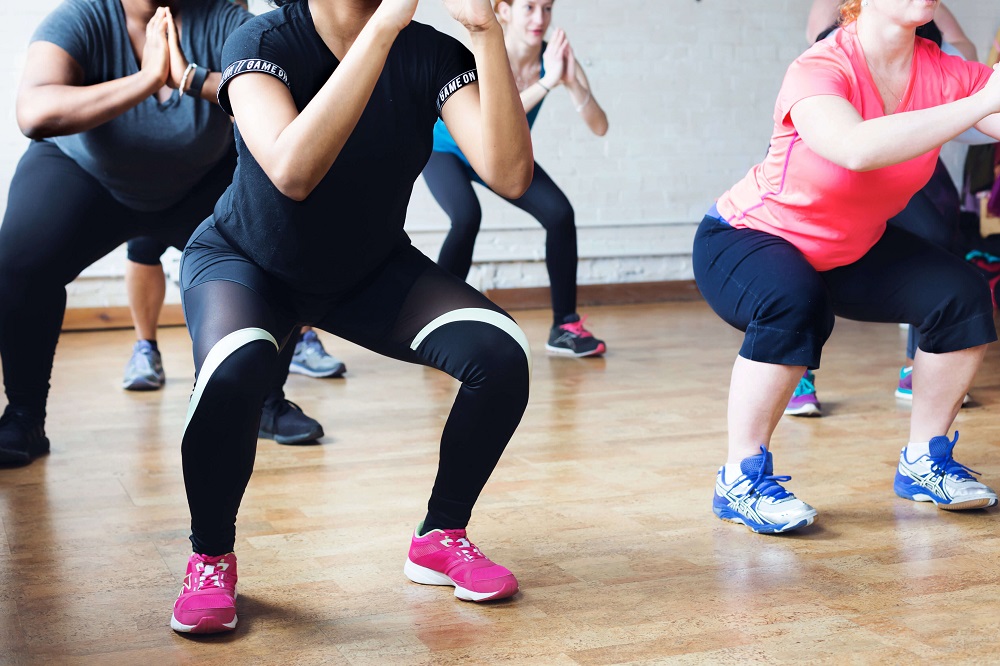 Women wearing exercise clothes doing squats